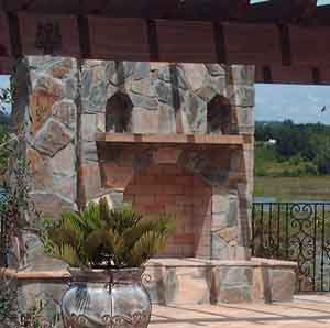 an outdoor fireplace by our hardscape contractor